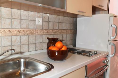 un tazón de naranjas sentado en un mostrador de cocina en Apartments Bibic, en Vodice