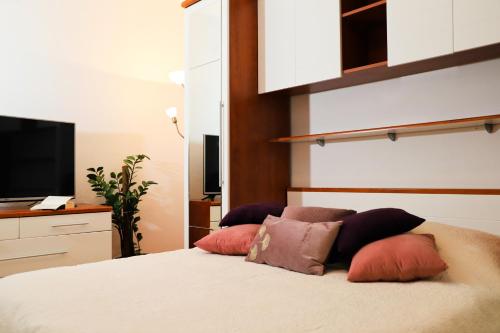 a bedroom with a bed with pillows and a television at Apartments Bibic in Vodice
