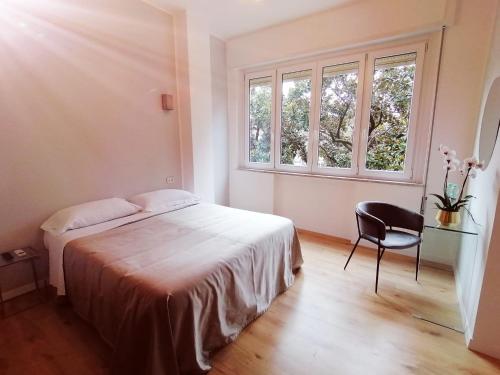 1 dormitorio con 1 cama, 1 silla y 2 ventanas en Guest House Arte, en Roma