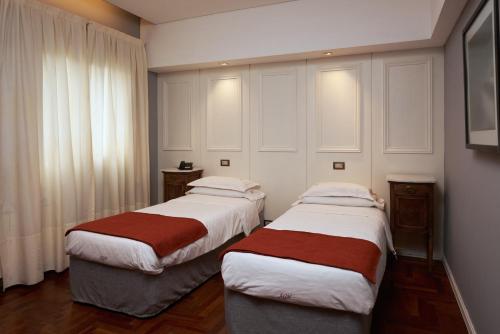 
a hotel room with two beds and two night stands at Altos de Guemes Hotel in Mar del Plata
