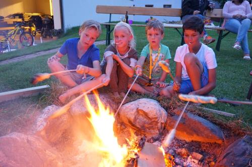 a group of children sitting around a campfire at Apart-Hotel Dreisonnenhof in Fiss