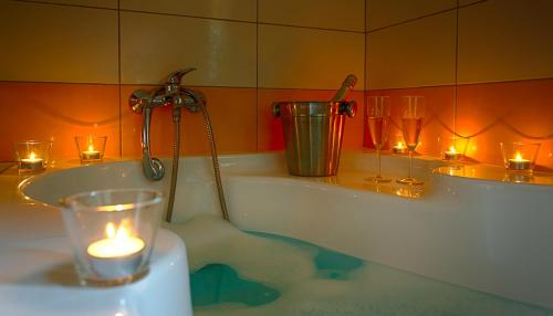 a bathroom with a candle in a bath tub with lights at Penzion Jelínek in Opočno