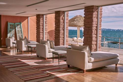 a row of couches and chairs in a room with the ocean at Titilaka - Relais & Châteaux in Tililaca