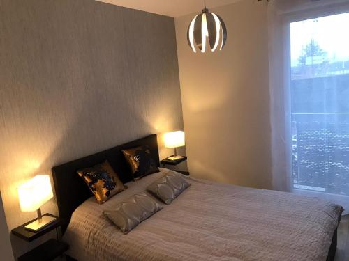 a bedroom with a bed with two lamps and a window at F3 standing in Les Ulis