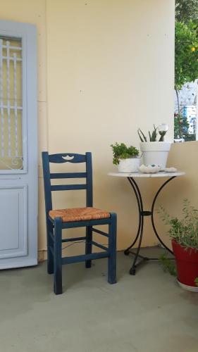 a blue chair sitting next to a table with potted plants at Cavos Seaside House in Vathi, Ithaka