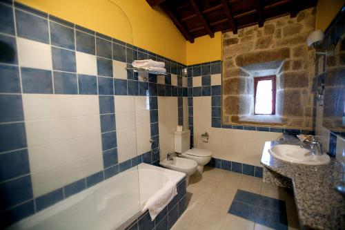 a bathroom with a tub and a toilet and a sink at Rectoral de Castillon in Pantón