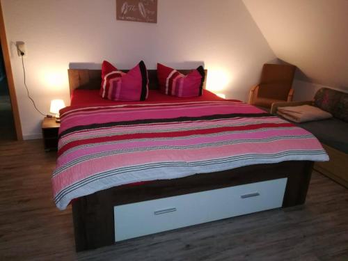 a bedroom with a large bed with pink pillows at Ferienhaus Betty in Rhauderfehn