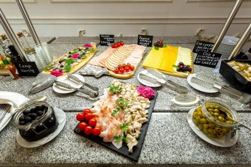 a counter topped with different types of food on plates at Bratislava Hotel Kyiv in Kyiv