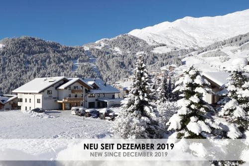 a resort in the mountains with snow covered trees at Apart-Hotel Dreisonnenhof in Fiss