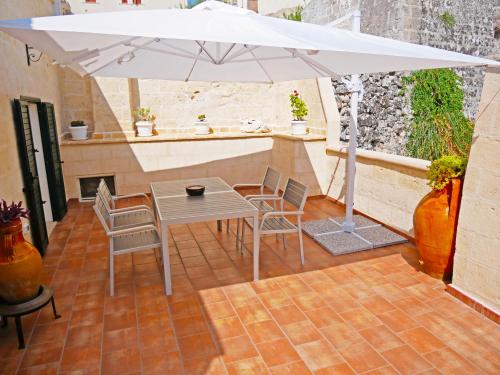 einen Tisch mit Stühlen und einem Sonnenschirm auf einer Terrasse in der Unterkunft Casa Sant'Agata in Laterza