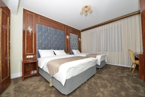 a bedroom with a large bed with a blue headboard at AHRA Hotel in Istanbul