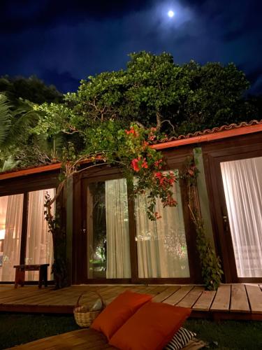 a house with a deck with flowers on it at Kûara Pipa in Pipa