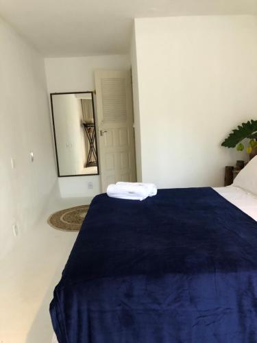 a bedroom with a blue bed with a mirror at Kûara Pipa in Pipa
