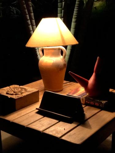 a lamp on a table with a book and a laptop at Kûara Pipa in Pipa