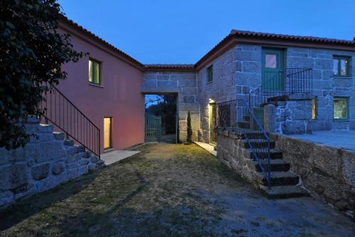 a stone house with a staircase in front of it at Quinta do Santinho in Amarante