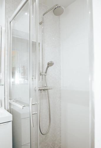 une douche avec une porte vitrée dans une salle de bain dans l'établissement Super Studio cosy - a 10 min de CDG aéroport - a 30 min de Paris - a 10 min du salon d'expo Villepinte, à Le Thillay