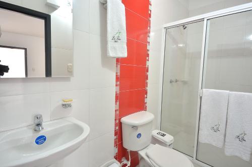 a bathroom with a toilet and a sink and a shower at La Pera Hotel in Bucaramanga