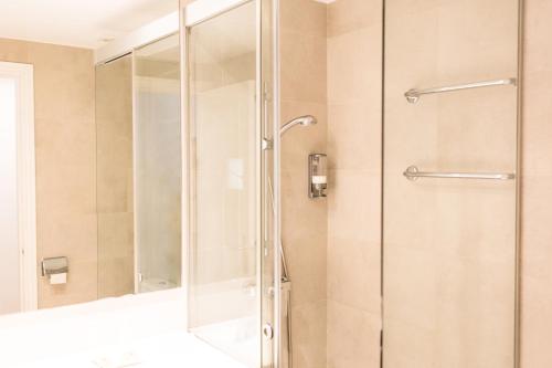 een douche met een glazen deur in de badkamer bij Sagitario Petit Ciutadella in Ciutadella