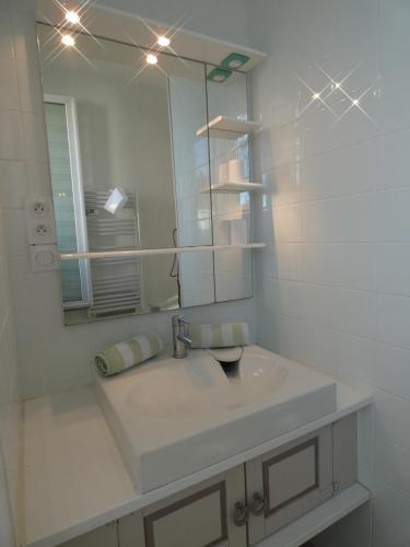 a white bathroom with a sink and a mirror at La Surprise in Étaples