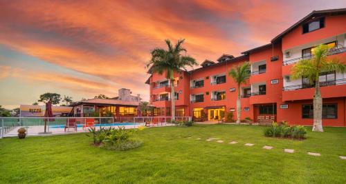 um grande edifício de apartamentos com um grande quintal com uma piscina em Rizzu Marina Hotel no Balneário Camboriú