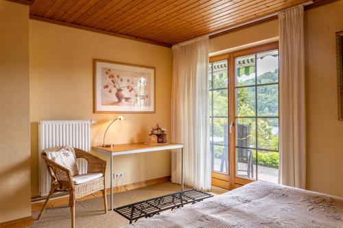 Schlafzimmer mit einem Bett, einem Schreibtisch und einem Fenster in der Unterkunft Ferienwohnung-Mediterran in Einruhr