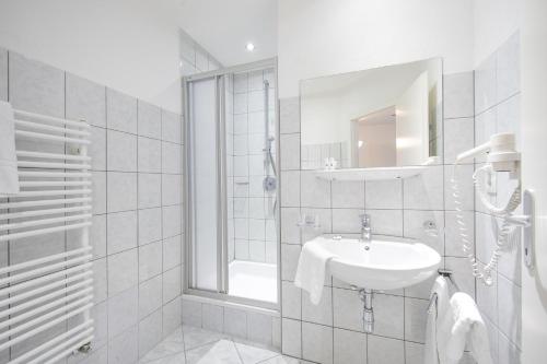 uma casa de banho branca com um lavatório e um chuveiro em Haus Veronika em Sölden
