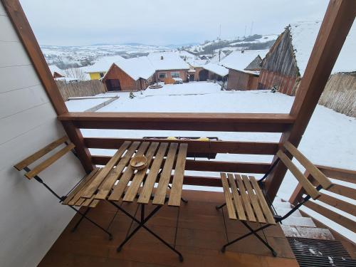 a wooden bench sitting on a balcony with snow at Flori Haus Saschiz in Saschiz