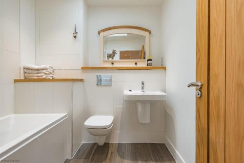 a bathroom with a toilet and a sink and a mirror at Cavallo Barn by Bloom Stays in Canterbury