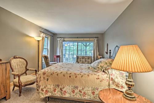 a bedroom with a bed and a chair and a window at Rustic and Modern Home with Fire Pit on Tower Pond! in Onaway