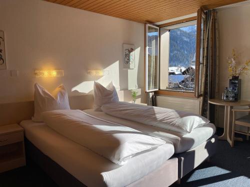 a large bed in a room with a window at Dinh Residence in Zweisimmen