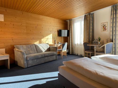 a hotel room with a bed and a couch at Dinh Residence in Zweisimmen
