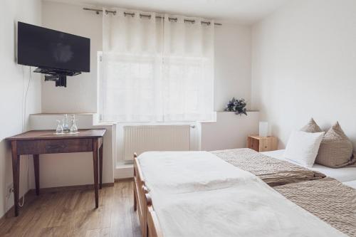 a bedroom with two beds and a flat screen tv at Schloß Destille in Dormagen