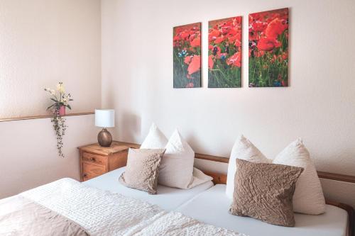 a bedroom with a bed and two paintings on the wall at Schloß Destille in Dormagen