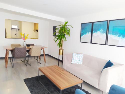 ein Wohnzimmer mit einem Sofa und einem Tisch in der Unterkunft 3 Apartamento completo Cedritos Minimalista in Bogotá