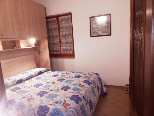 a bedroom with a bed with a floral comforter at Casa Lella in Domaso