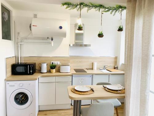 a kitchen with a washing machine and a table at Studio ScandiChic tout équipé centre-gare-rives-clinique à pied in Caen
