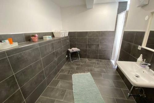 a bathroom with a sink and a tiled floor at Schickes & gemütliches City Apartment 72qm 3Zimmer in Paderborn