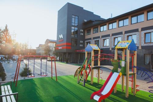 un parque infantil con tobogán en una ciudad en Magnum, en Beregovo