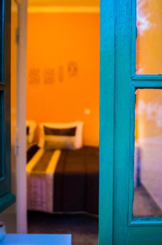 a bedroom with a bed in an orange room at Refugio do Rossio in Avis