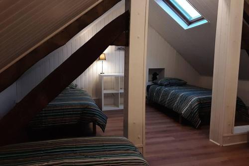 Zimmer im Dachgeschoss mit 2 Betten und einem Dachfenster in der Unterkunft Proche de Bayeux, près des plages du débarquement, à la campagne in Crouay