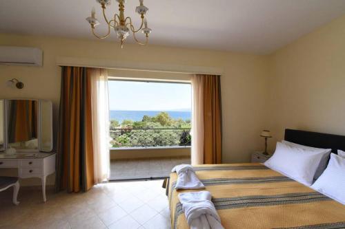 een slaapkamer met een bed en een groot raam bij Seaside Villa AndroNikos (Evia Island) in Amarinthos