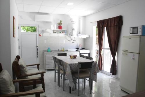 a kitchen with a table and chairs and a refrigerator at ALOJAMIENTO SARMIENTO in General Alvear
