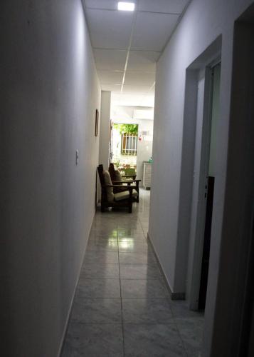 a hallway with a chair and a couch in a room at ALOJAMIENTO SARMIENTO in General Alvear
