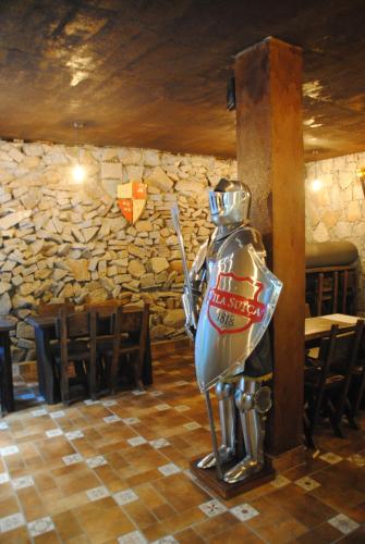 a statue of a knight in front of a stone wall at Hotel Vila Suíça 1818 in Nova Friburgo