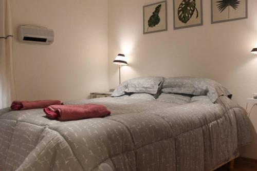 1 dormitorio con 1 cama con 2 almohadas rojas en Nuevo Abrojal: departamento en Barrio Güemes en Córdoba