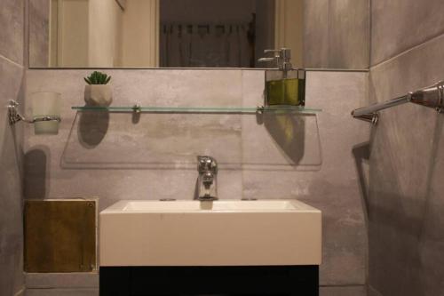 y baño con lavabo blanco y espejo. en Nuevo Abrojal: departamento en Barrio Güemes en Córdoba