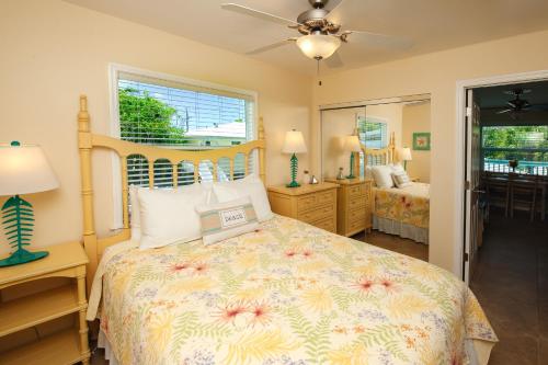 a bedroom with a large bed and a mirror at Cedar Cove Resort & Cottages in Holmes Beach