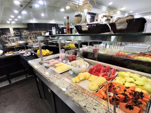 a counter filled with lots of different types of food at Granville Hotel in Curitiba