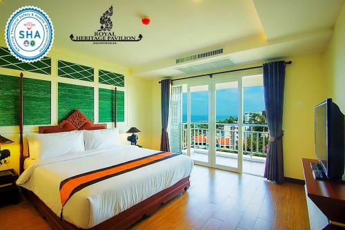 a bedroom with a bed and a television and a balcony at Royal Heritage Pavilion, Jomtien in Jomtien Beach