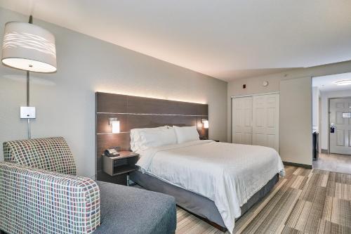 a hotel room with a bed and a chair at Holiday Inn Express Hotel & Suites Clearwater US 19 North by IHG in Clearwater